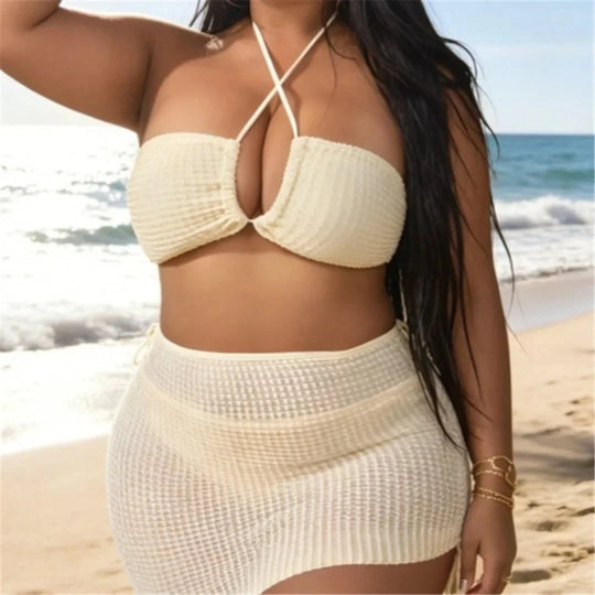 Maillot de bain trois pièces grande taille beige porté de face sur la plage, bustier à bretelles croisées nouées