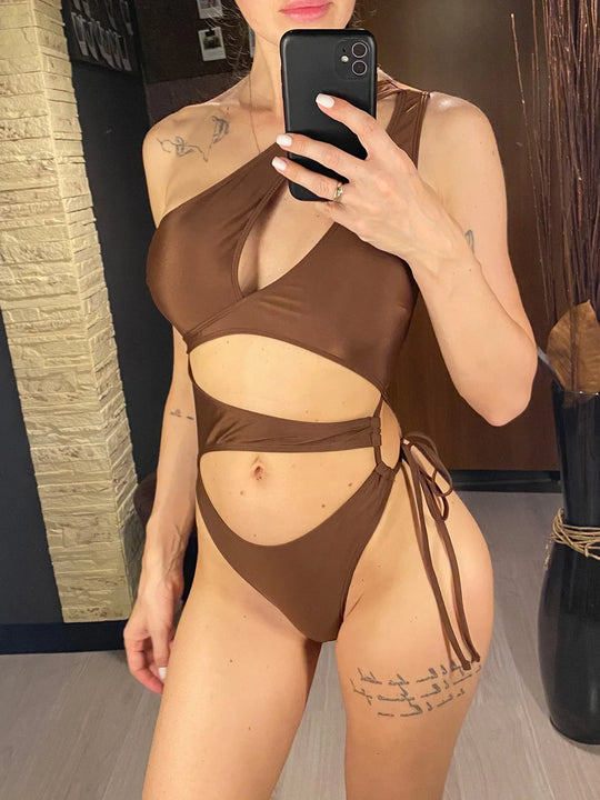 Maillot de bain une pièce asymétrique marron avec anneau doré et lien latéral, porté de face en selfie au miroir