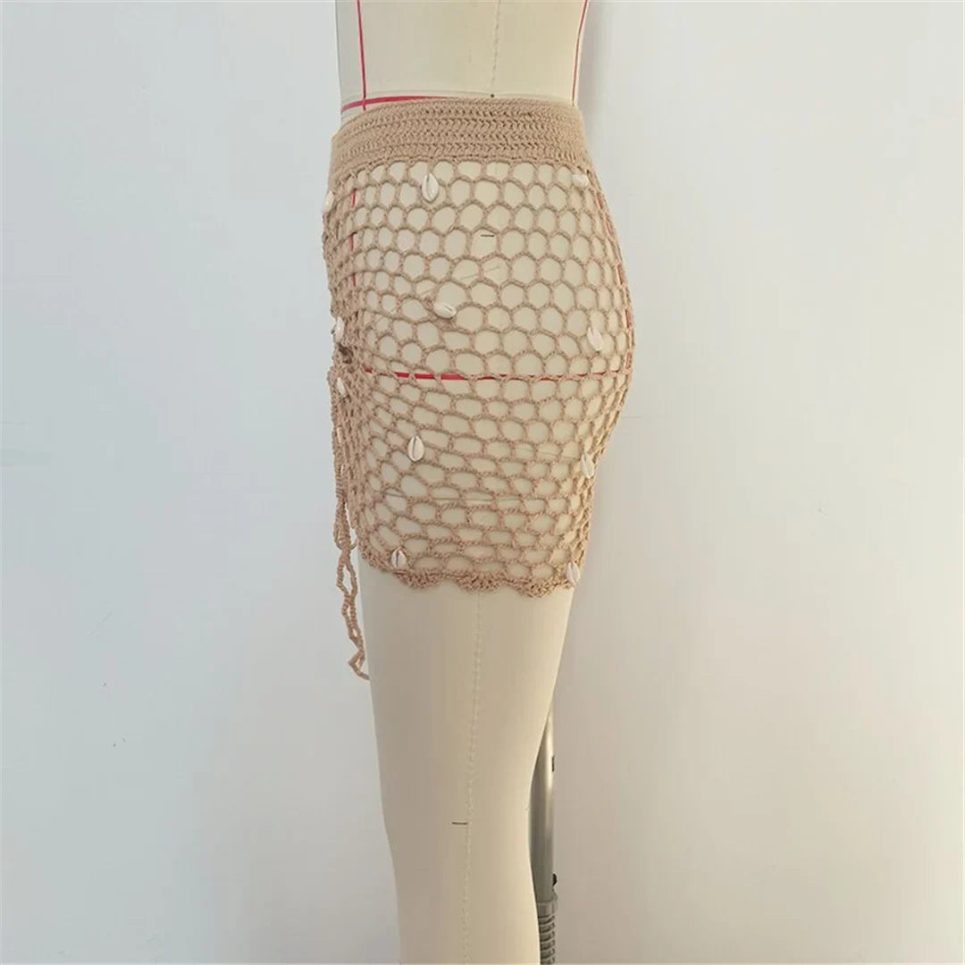 Jupe de plage beige clair en crochet ajouré vue de profil sur mannequin, maille ouverte et bord festonné en bas