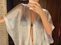 Gros plan sur le haut du kimono de plage à franges en maille brillante blanc