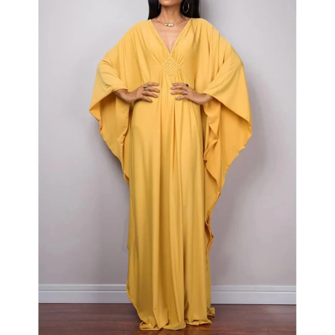 Robe de plage longue kaftan manches chauve-souris jaune portée de face, mains sur les hanches et col V tressé au buste