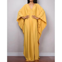 Robe de plage longue kaftan manches chauve-souris jaune portée de face, mains sur les hanches et col V tressé au buste