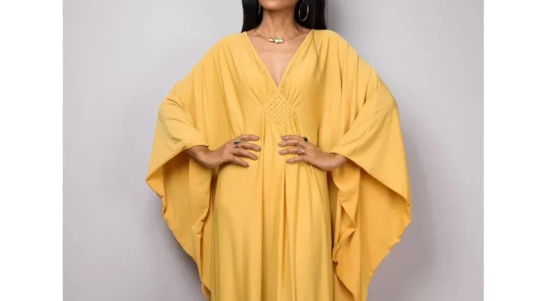 Gros plan sur le haut du robe de plage longue kaftan manches chauve-souris jaune moutarde