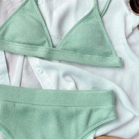 Gros plan sur le haut triangle côtelé vert menthe sans armatures et la ceinture de la culotte taille haute