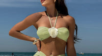 Gros plan sur le haut du trikini avec jupe froncée et fleurs en relief vert pistache