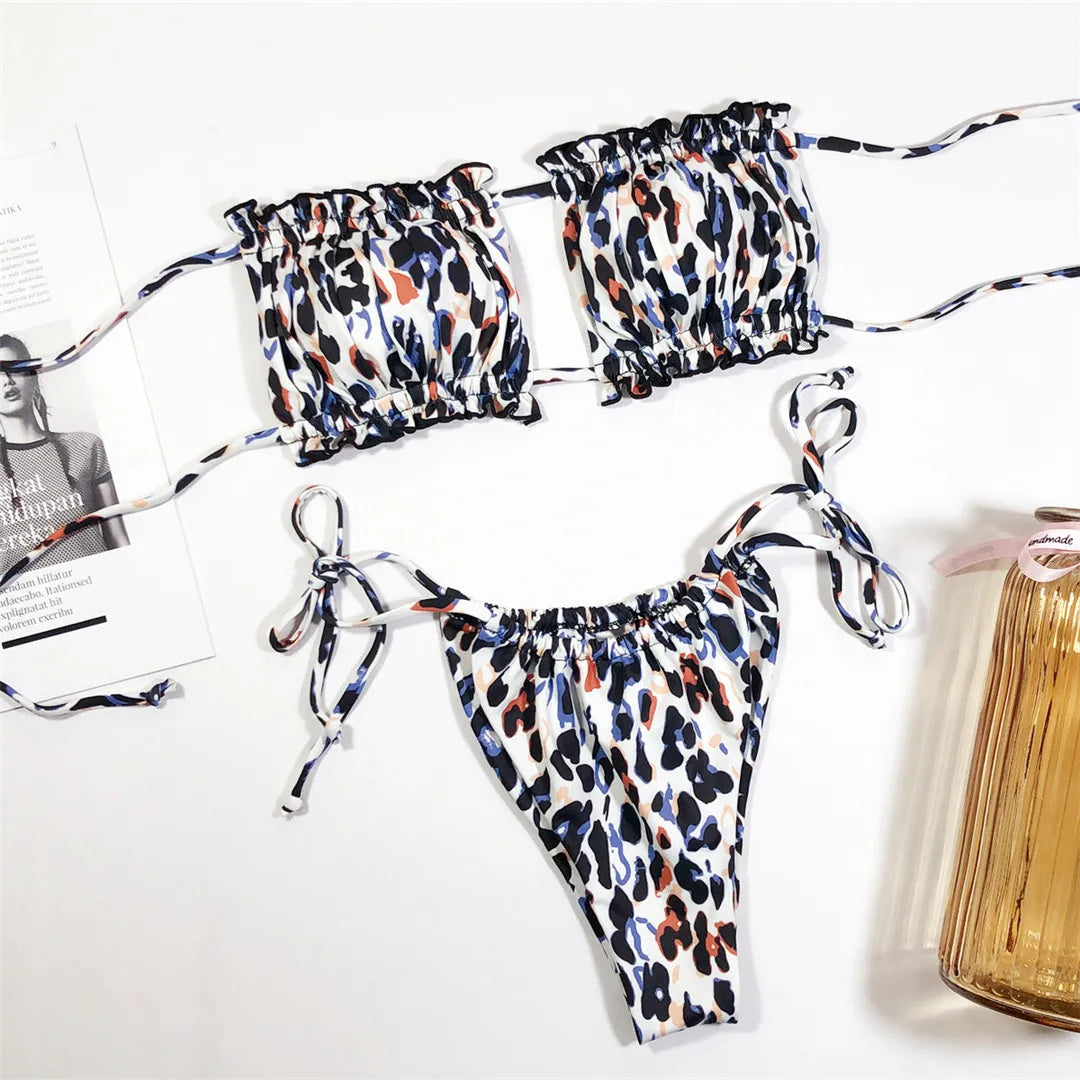 Bikini imprimé léopard à plat sur un fond blanc, bandeau froncé à deux bonnets et bas à liens noués sur les côtés