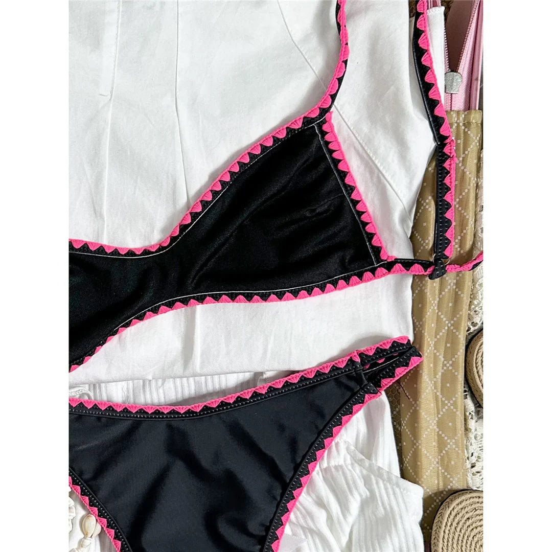 Bikini brésilien triangle imprimé fleuri noir et rose, gros plan sur le bas et les fleurs rouges sur fond noir