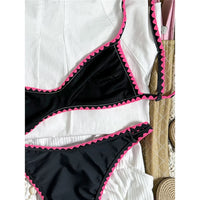 Bikini brésilien triangle imprimé fleuri noir et rose, gros plan sur le bas et les fleurs rouges sur fond noir