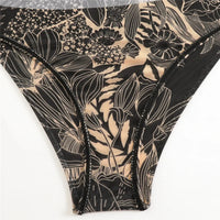 Gros plan sur la culotte du body en mesh noir à motifs floraux beiges, taille haute et bordure fine