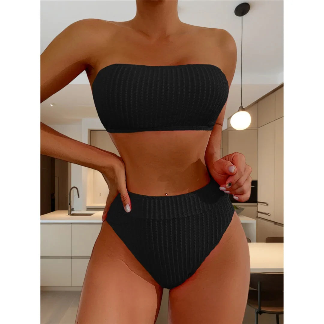 Bikini bandeau taille haute texturé noir porté de face par une femme debout dans une cuisine, haut côtelé et bas taille haute
