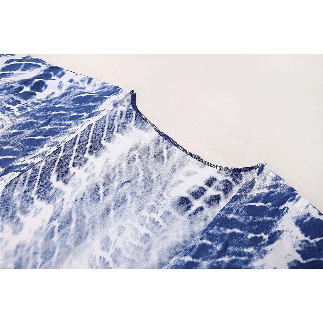 Gros plan sur le tissu bleu foncé à motifs blancs de la tunique de plage manches longues, bord de col visible