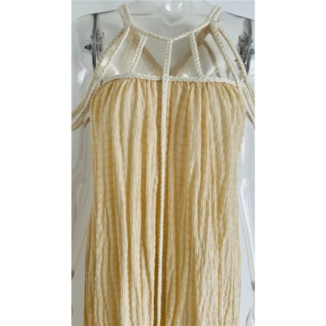 Gros plan sur le haut d'une robe beige en crépon, cordes tressées et bretelles larges sur la poitrine