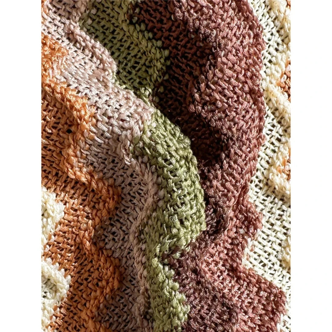 Gros plan sur la texture tricotée rayée marron, vert, orange et rose du bikini brésilien, chevrons en relief