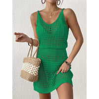 Tunique de plage en crochet ajourée verte portée de face, col en V et tenant un sac en paille tressé