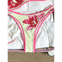 Bikini brésilien triangle imprimé fleuri beige, gros plan sur la culotte et son bord festonné rose vif