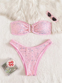 Bikini bandeau à sequins brillants taille basse rose à plat sur fourrure blanche, lunettes de soleil roses posées en haut