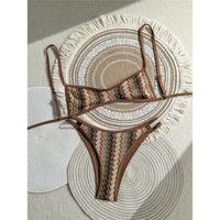 Bikini brésilien triangle sans armatures rayé marron et vert posé à plat sur des sets en paille, bordure marron et bretelles