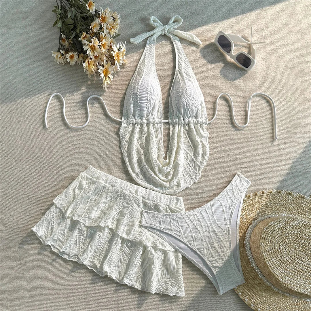 Maillot de bain trois pièces tankini avec jupe texturé blanc posé à plat avec bouquet de marguerites et lunettes