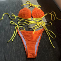 Bikini col halter croisé à effet froissé rouge orangé posé à plat, lacets jaune fluo longs et slip froncé