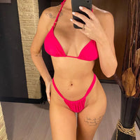 Bikini string triangle froncé échancré taille basse rose vif porté de face devant un miroir, bretelles fines nouées au cou