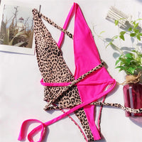 Maillot de bain une pièce triangle croisé imprimé léopard rose fuchsia posé à plat, lanières fuchsia et partie léopard