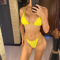 Bikini string tour de cou à anneau métallique froncé jaune porté de face devant un miroir, anneaux sur les côtés