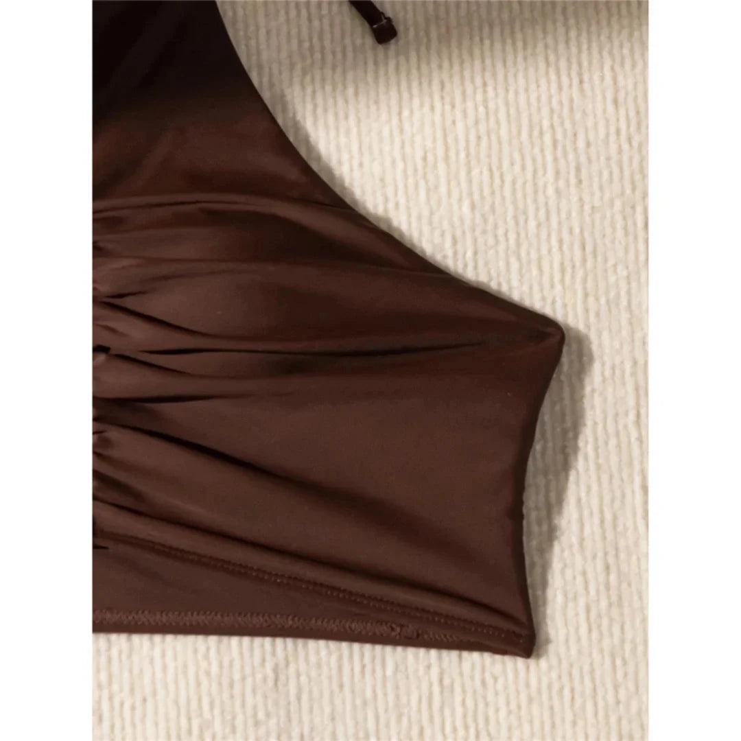 Gros plan sur le haut bikini taille haute texturé marron café, tissu froncé et ourlet lisse sur fond crème