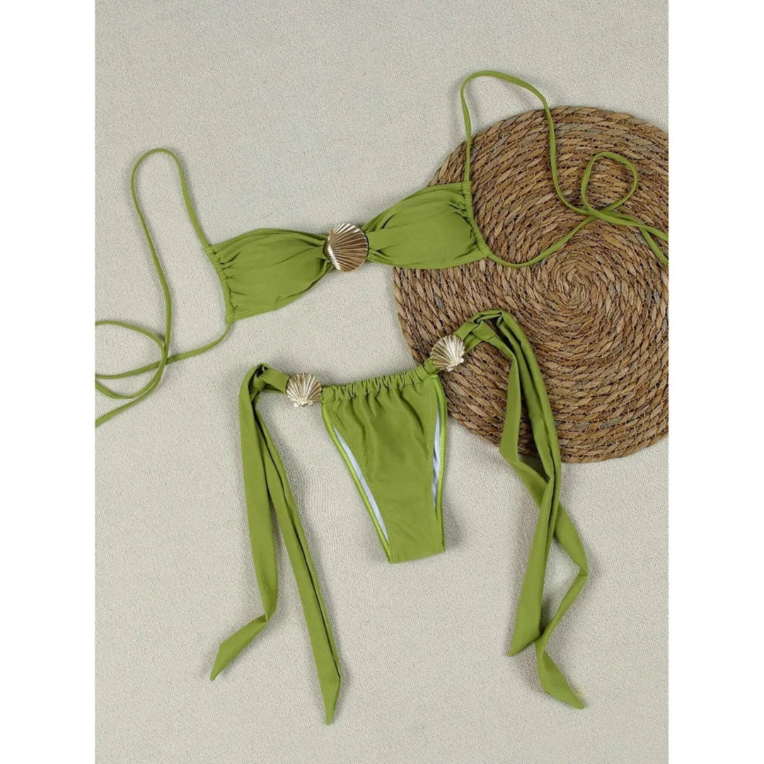 Bikini tour de cou à détail coquille métallique échancré vert à plat sur fond beige, coquille dorée au centre