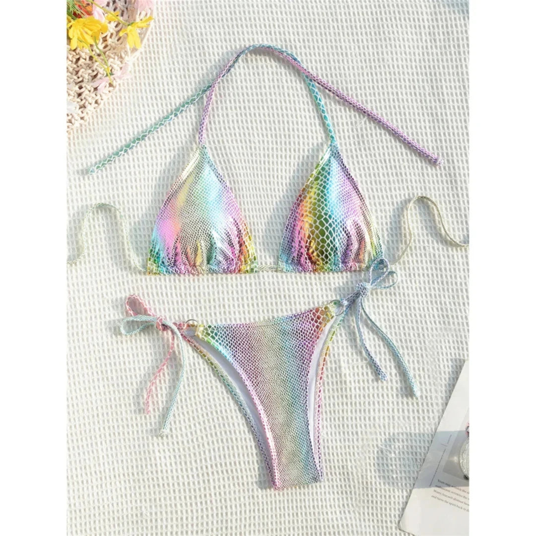 Bikini imprimé serpent multicolore posé à plat sur un tissu blanc texturé, longues lanières et bas à liens
