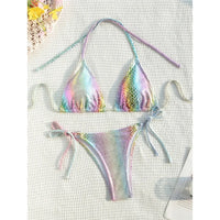 Bikini imprimé serpent multicolore posé à plat sur un tissu blanc texturé, longues lanières et bas à liens