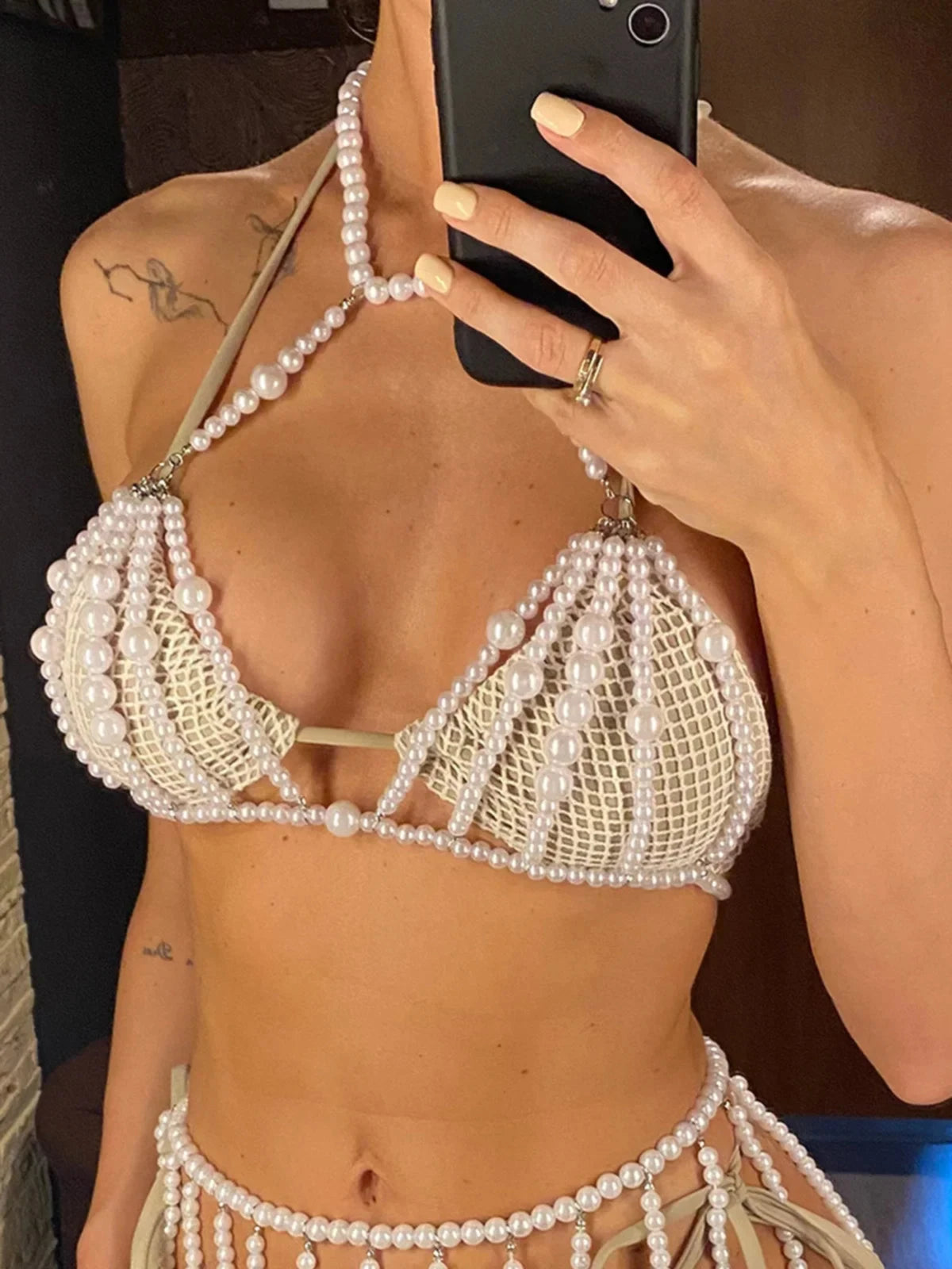 Haut de plage à perles ajouré tour de cou blanc porté de face en selfie au miroir, rangs de perles sur le buste et le ventre