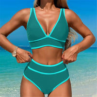 Bikini bleu paon décolleté en V porté de face, mains sur les hanches, liserés turquoise sur le haut et la taille