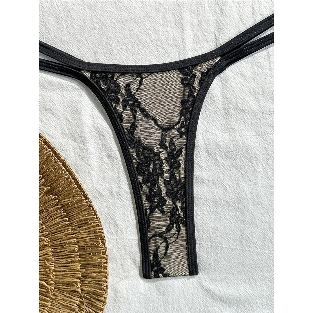 Gros plan sur le bas en dentelle noire du bikini string micro, fine bordure et bretelles doubles sur la hanche