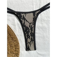 Gros plan sur le bas en dentelle noire du bikini string micro, fine bordure et bretelles doubles sur la hanche