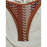 Gros plan sur le bas échancré rouge brique à motifs vagues beiges, double bride latérale et bordure contrastée
