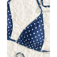 Gros plan sur le haut triangle bleu foncé à pois blancs, posé sur une fourrure blanche