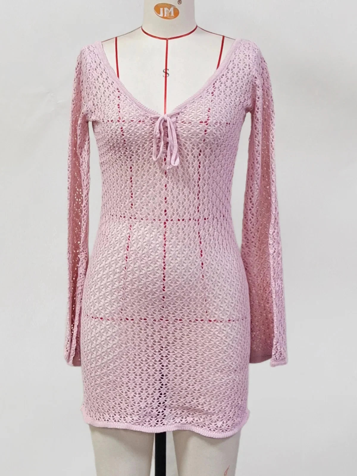 Tunique de plage crochet ajourée rose de face sur mannequin, gros plan sur le buste et le lien noué au col en V