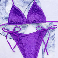 Gros plan sur le bikini tour de cou violet à motif gaufré, triangle rembourré et liens latéraux