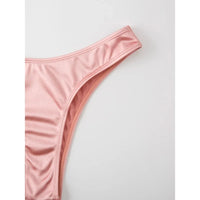 Gros plan sur le bas rose taille basse du bikini bandeau, coupe échancrée sur la hanche, fond blanc