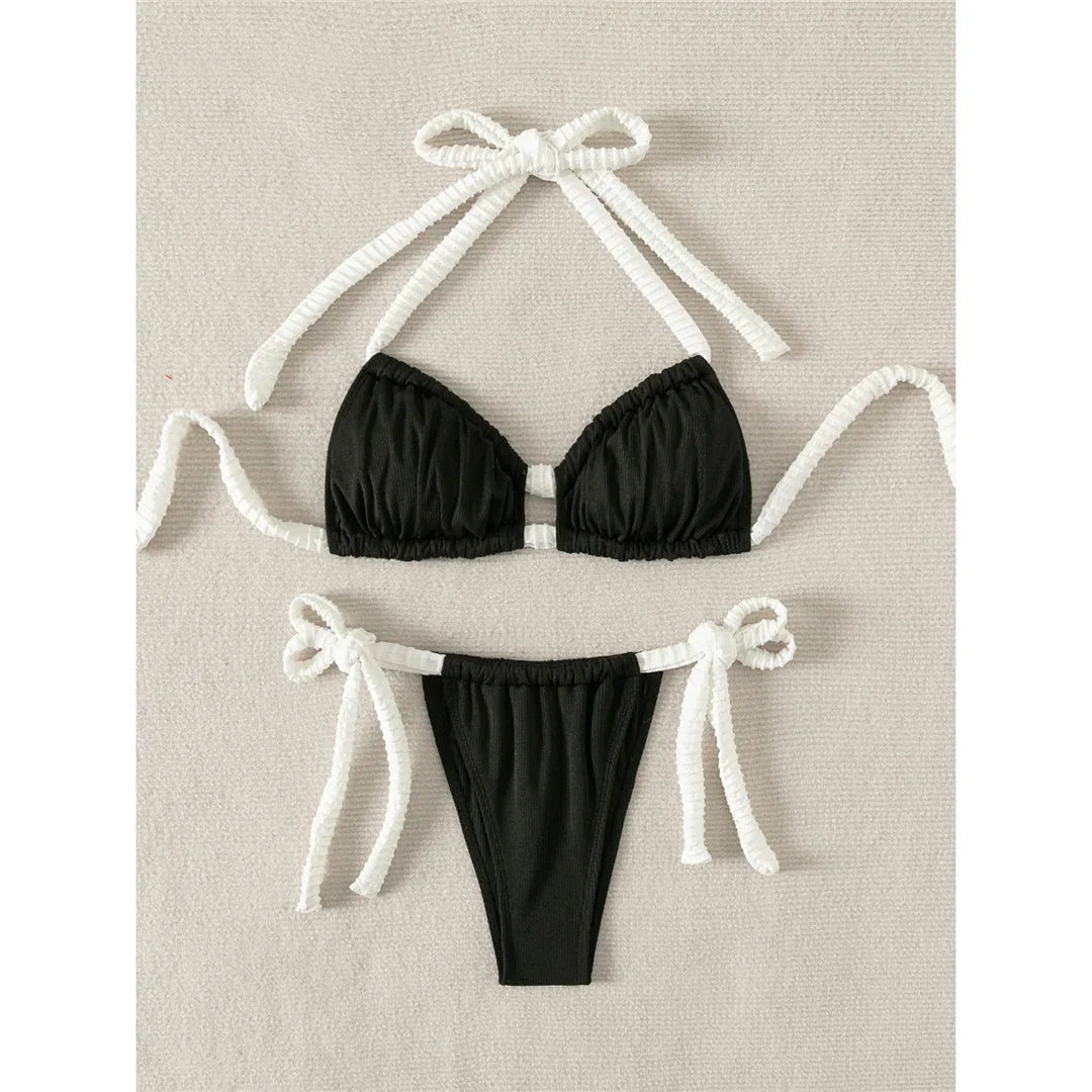 Bikini côtelé tour de cou échancré à fines lanières noir à plat sur fond clair, avec nœuds blancs sur les côtés