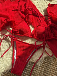 Maillot de bain rouge quatre pièces avec jupe et haut à manches longues volantées, photographié en gros plan