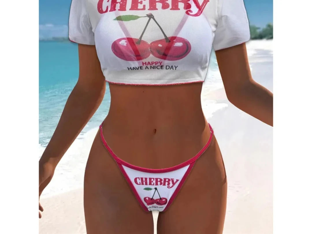 Maillot trois pièces crop top blanc à imprimé cerises et liseré rose fuchsia, porté de face en selfie