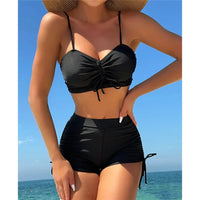 Bikini taille haute short froissé noir porté de face par une femme au chapeau de paille, bretelles fines et haut froncé