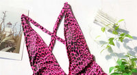 Gros plan sur le haut du maillot une pièce croisé décolleté plongeant léopard rose