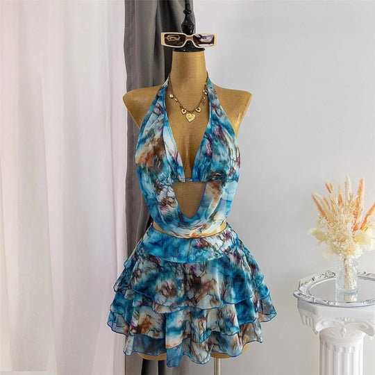 Trikini bleu imprimé marbré, col halter et jupe volantée à plusieurs volants, présenté sur un mannequin de boutique