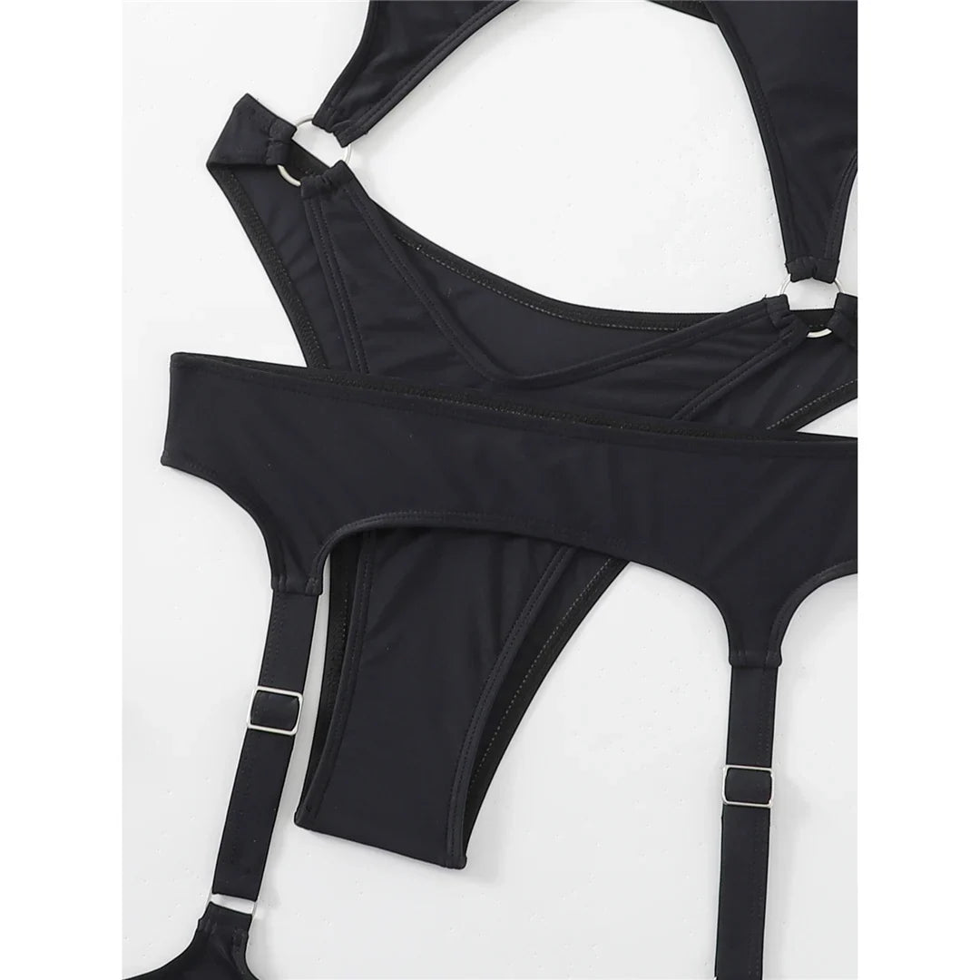 Gros plan sur les anneaux et sangles de jarretière d'un maillot noir à découpes, boucles métalliques réglables