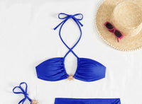 Gros plan sur le haut du maillot trois pièces avec jupe portefeuille et haut halter bleu roi