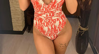 Gros plan sur le bas du maillot une pièce croisé décolleté plongeant imprimé serpent rouge