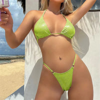 Bikini tour de cou pailleté échancré taille basse vert fluo porté de face sur la plage, triangle brillant et anneaux