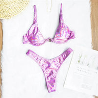 Bikini à armatures rembourré violet clair irisé posé à plat sur une fourrure blanche, haut en V profond